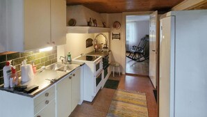A compact kitchen with white cabinets, a wooden ceiling, and a small stool. - Beautiful home in Vena with WiFi (Vena)