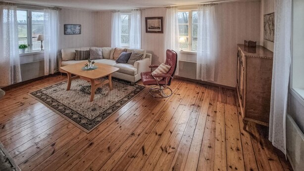 A cozy living room with a wooden floor, a sofa, a chair, and a coffee table. - Beautiful home in Vena with WiFi (Vena)