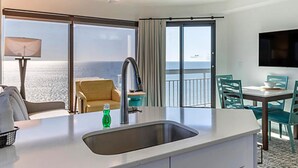 A hotel room with a balcony, a sink, a chair, a table, and a TV. - SEAGLASS TOWER MYRTLE BEACH 6 NIGHTS Sept 28-Oct 4,2026 DELUXE OCEANFRONT 1 BDRM (Myrtle Beach)