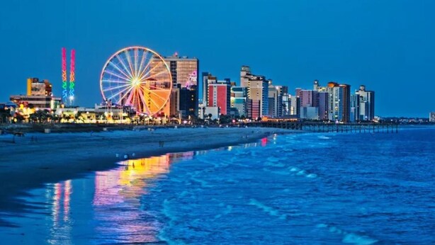 A coastal cityscape with a prominent Ferris wheel and modern high-rise buildings. - SEAGLASS TOWER MYRTLE BEACH 6 NIGHTS Sept 28-Oct 4,2026 DELUXE OCEANFRONT 1 BDRM (Myrtle Beach)