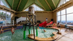 An indoor pool with a water slide, a wooden structure, and a view of the outdoors. - ML 270: Dazzling 3BR with unbeatable mountain views! Bike-in/out! (Snowshoe)