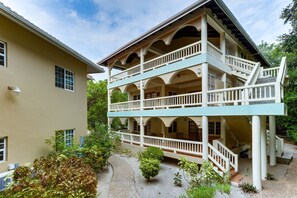 Un immeuble de deux étages doté d’un balcon et d’un escalier.