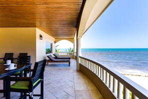 A covered outdoor seating area with a view of the ocean.