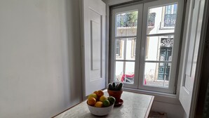 Ein Essbereich mit einem Marmortisch, einer Obstschale und einem in einem Topf stehenden Kaktus.