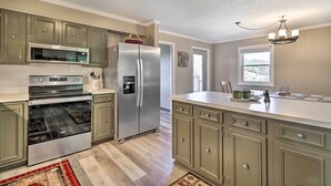 A kitchen with a stainless steel refrigerator, oven, and microwave, light green cabinets, and a wooden floor. - Welcoming Boone Getaway Near Hiking + Skiing! (Boone)