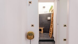 A hallway with a potted cactus, a wooden ladder, and a bench.