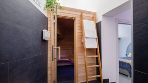 A modern room with a wooden sauna door, a wooden ladder, and a bench.