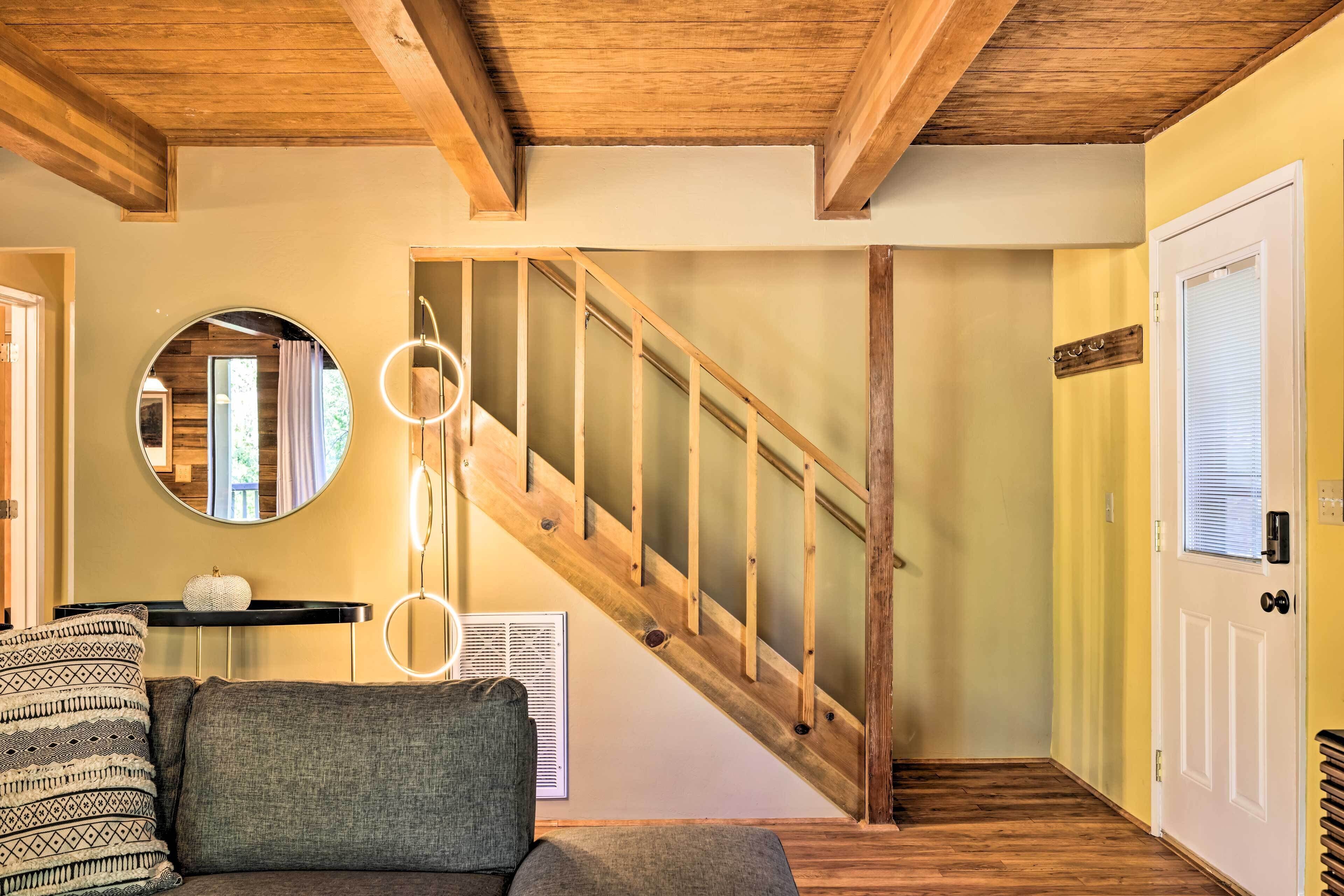 Una escalera con barandillas de madera y un espejo circular en la pared.