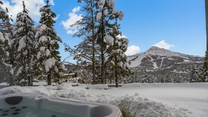 A hot tub in a snowy landscape with a mountain in the background. - Ski-In/Ski-Out Updated Big Sky Retreat (Big Sky)