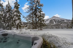 A hot tub in a snowy landscape with a mountain in the background. - Ski-In/Ski-Out Updated Big Sky Retreat (Big Sky)