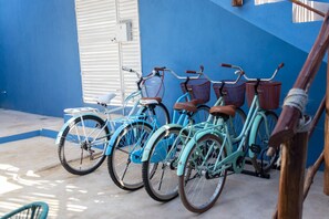 A row of bicycles parked against a blue wall, with a white door and a power outlet visible. - Luxury 6-Bed 6-Bath. An Entire Private Villa w/plung pool. Beach & 5th Ave-walking distance (Playa del Carmen)