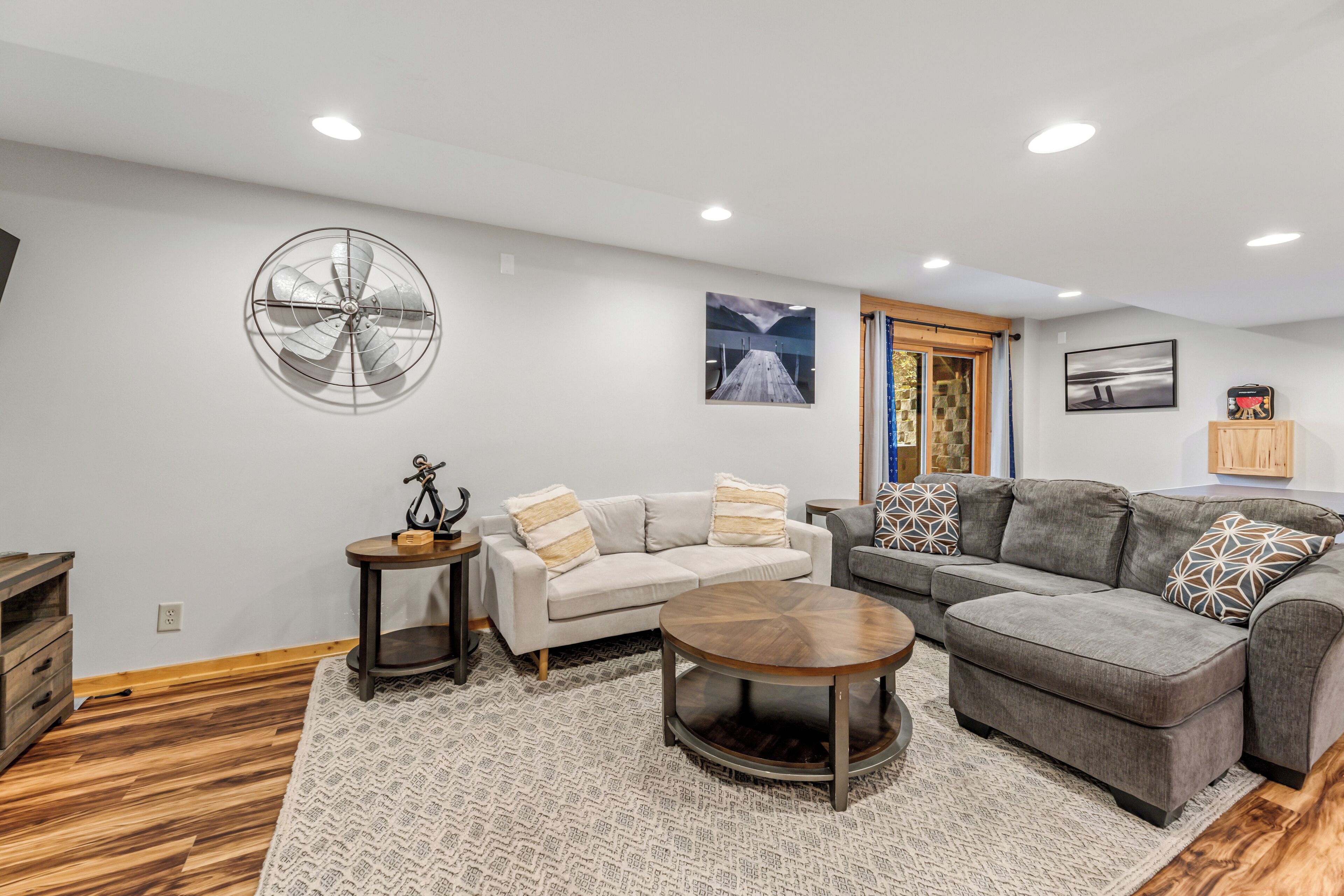 A modern living room with a sofa set, a coffee table, and a decorative fan.