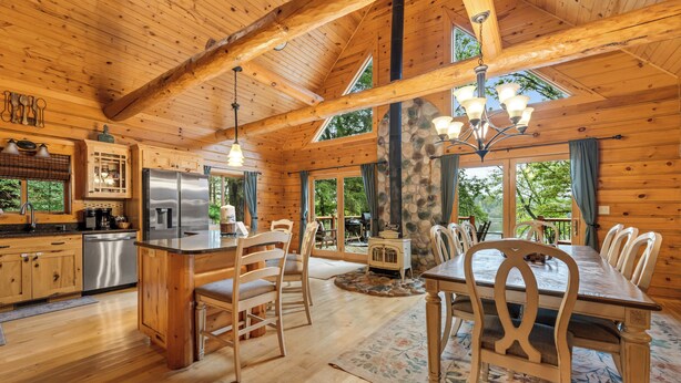 Un'ampia baita in legno con cucina, zona pranzo e ampie finestre.