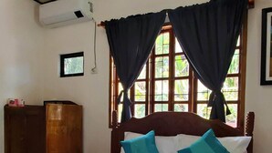 A neatly made bed with a white comforter, teal pillows, and a rolled towel. - Private quite bungalow-5 min walk to ocean & restaurants (Moalboal)