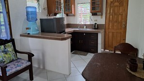 A compact kitchen with a water dispenser, a refrigerator, a sink, and wooden cabinets. - Private quite bungalow-5 min walk to ocean & restaurants (Moalboal)