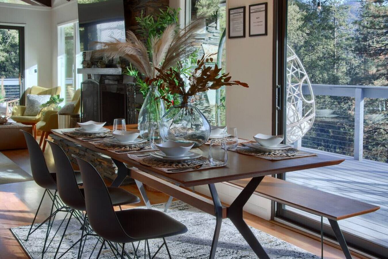 Un comedor moderno con una larga mesa dispuesta para seis personas, rodeada de sillas negras.