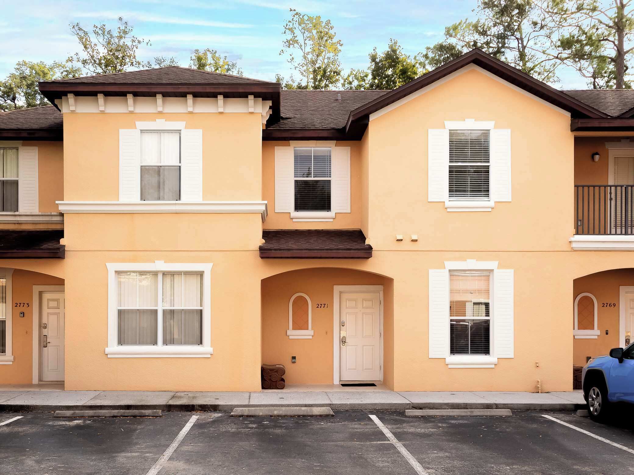 A row of townhouses with a parking lot in front.