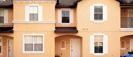 A row of townhouses with a parking lot in front.