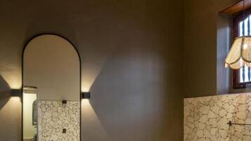 Een moderne badkamer met een vrijstaand wastafelmeubel, een grote spiegel en een toilet.