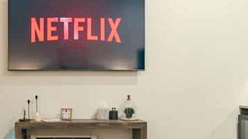 Un téléviseur fixé au mur affiche le logo de Netflix.
