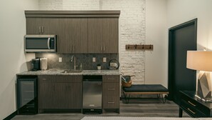 Una cucina moderna con pensili in legno scuro, un forno a microonde integrato e una lavastoviglie in acciaio inossidabile.