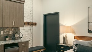 Una camera da letto moderna con un letto, un comodino, una lampada e una panca.