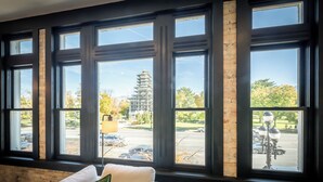 A room with a large window overlooking a parking lot and a construction site. - Luxury Suite ~ Above Starbucks ~ Main St View (Logan)