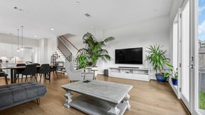 Un grand espace de vie comprenant une table à manger, un canapé et un téléviseur.