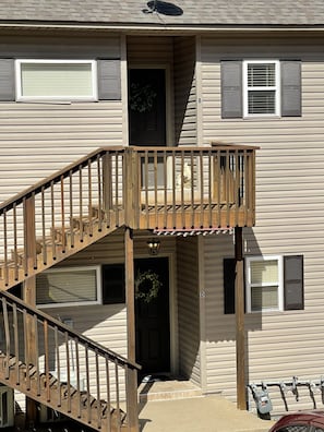 A two-story building with a wooden staircase leading to a balcony. - October dates available! Perfect condo for taking in the changing leaves!! (Hot Springs)