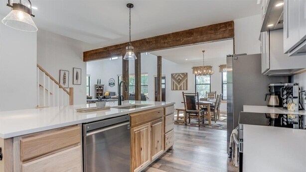 Una cocina moderna con una isla central, electrodomésticos de acero inoxidable y armarios de madera.