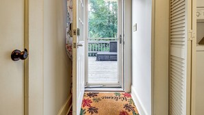 A hallway leading to a door with a doormat, a view of a deck, and a window with blinds. - Hike & Bike On-Site: Burgaw Apt - 4 Mi to River (Burgaw)