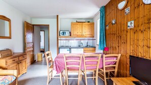 A compact kitchen with wooden cabinets, a microwave, and a coffee maker.