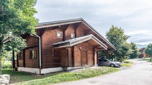 A wooden cabin with a porch, a car parked in front, and a mountain backdrop. - Splendid chalet 8/10 ppl, large terrace, parking (Morillon)
