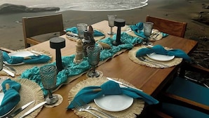 A table set for two with a view of the ocean and a cliff. - Ocean View 4 Bedroom Villa Steps to Beach & Resort Amenities (Guanacaste Province)