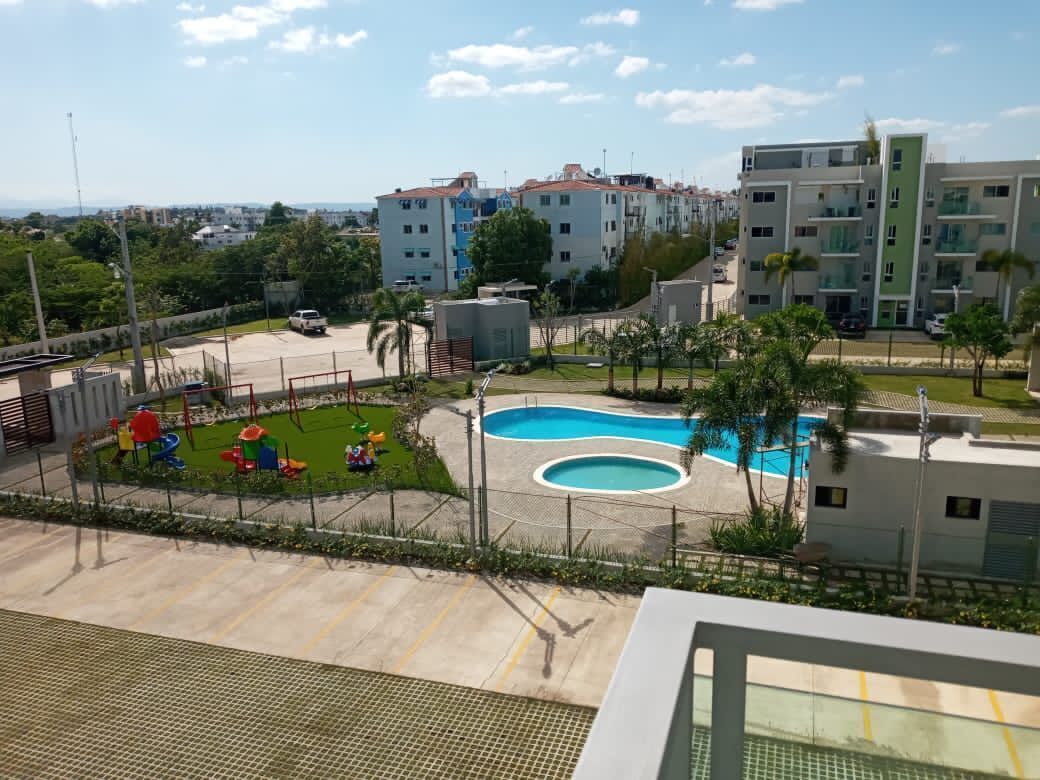 Zona residencial con piscina, parque infantil y edificios de apartamentos modernos.