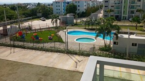Zona residencial con piscina, parque infantil y edificios de apartamentos modernos.
