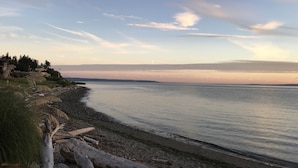 Un paysage côtier avec une mer calme, une côte rocheuse et un horizon lointain.