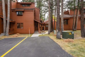A multi-story wooden building with a driveway leading to a covered entrance.