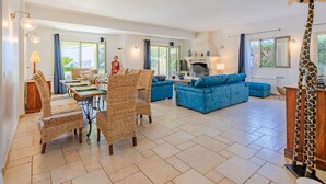A spacious living area with a dining set, blue sofas, and a giraffe statue. - Stunning private villa for 8 people with A/C, WIFI, private pool, TV and terrace (Saint-raphaël)