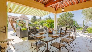An outdoor patio with a table set for dining, surrounded by wicker chairs and a pergola overhead. - Stunning private villa for 8 people with A/C, WIFI, private pool, TV and terrace (Saint-raphaël)