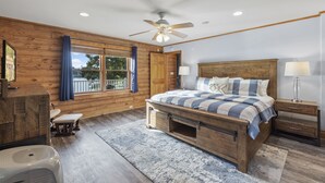 Un dormitorio con una cama de madera, un ventilador de techo, una mesita de noche y una ventana con cortinas.