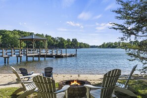 Une terrasse au bord du lac, dotée de chaises Adirondack, d’un foyer et d’un belvédère.
