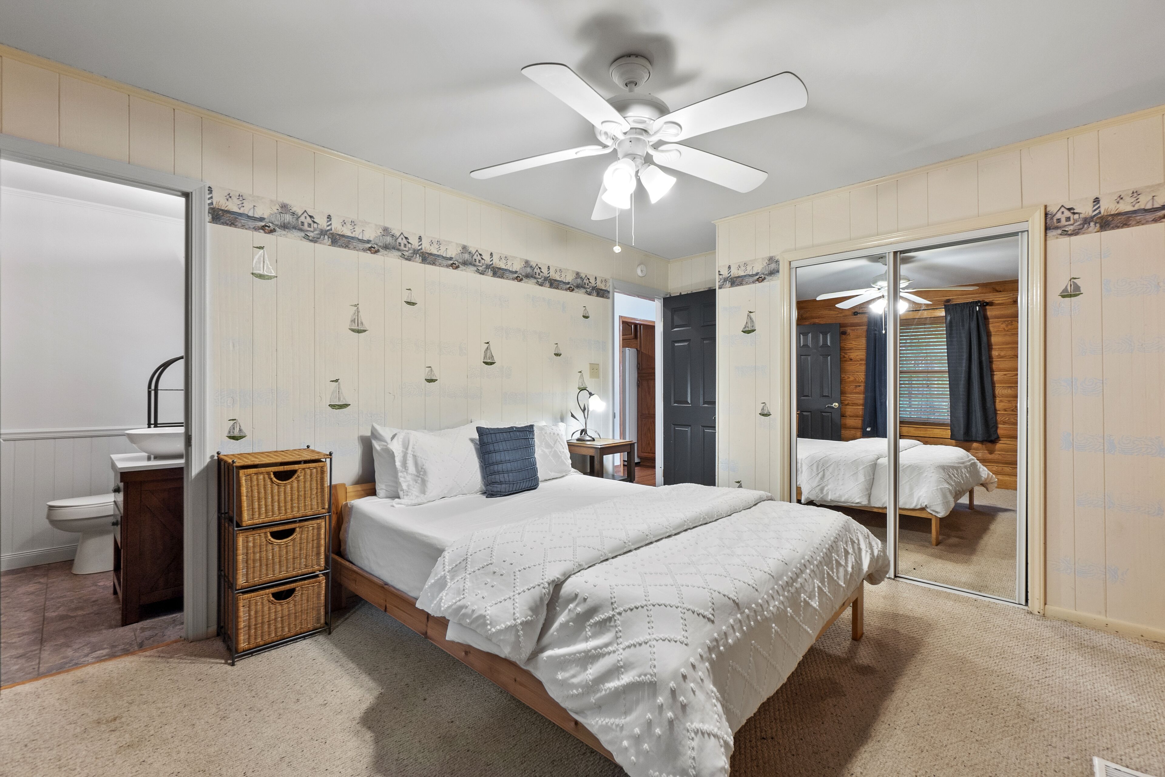A bedroom with a bed, bedside tables, a wardrobe, and a mirror.