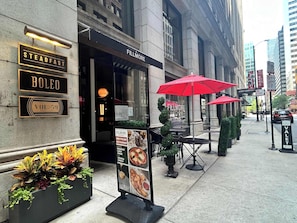 Un restaurante llamado Steadfast Boleo con terraza y sombrillas rojas.