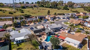 Un quartier résidentiel avec des maisons, une piscine et des panneaux solaires.