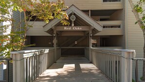 A building entrance with a sign reading "Red Oaks" and a covered walkway leading to a parking area.