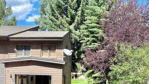 A two-story house with a garage, a satellite dish, and a well-maintained lawn with a stone pathway. - Golf & Ski Townhome in Avon, Colorado (Avon)