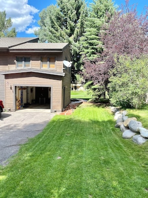 A two-story house with a garage, a satellite dish, and a well-maintained lawn with a stone pathway. - Golf & Ski Townhome in Avon, Colorado (Avon)