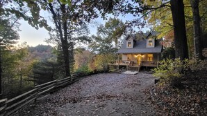 A rustic cabin with a porch, surrounded by a forested area. - Cozy Mountain Chalet with views, private setting! Near WCU and Castle Ladyhawke  (Cullowhee)