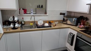 A compact kitchen with a sink, countertop, and oven.